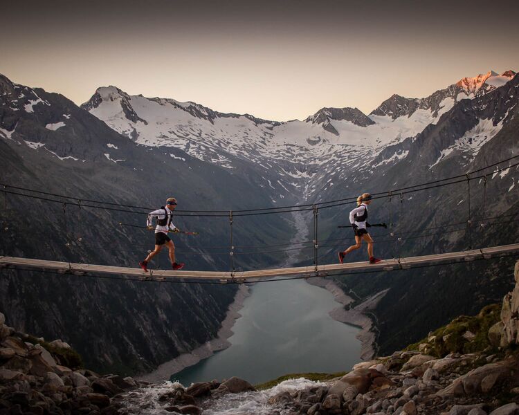 Hängebrücke über dem türkisfarbenen Schlegeisspeicher im Zillertal mit Bergpanorama — beliebter Wander- und Fotospot. © CrazyProjects / Philipp Reiter