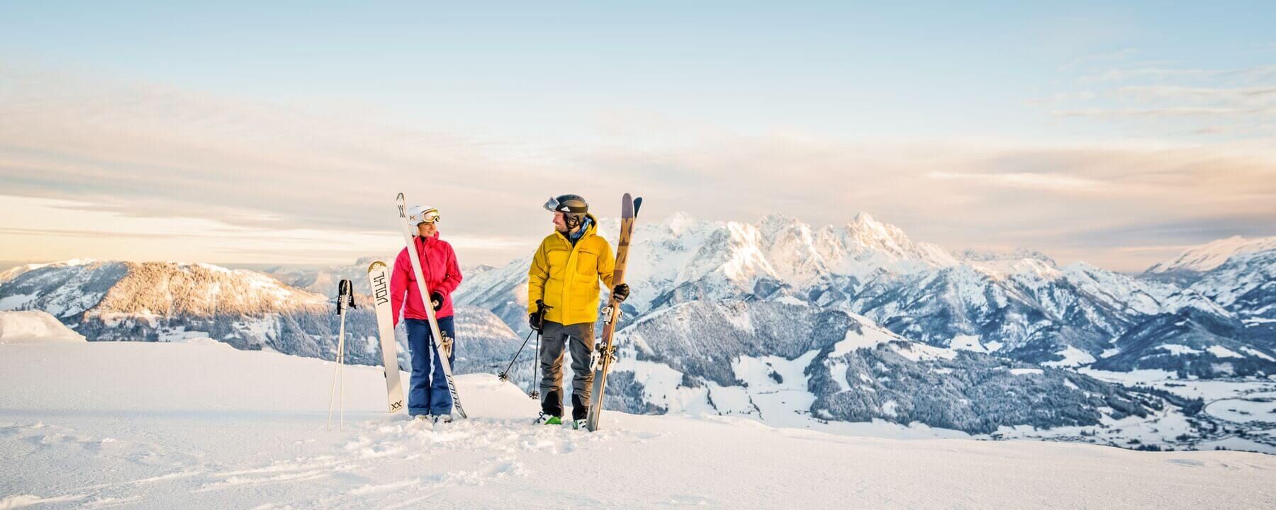Skiers in front of a wintry mountain panorama in the Kitzbühel Alps