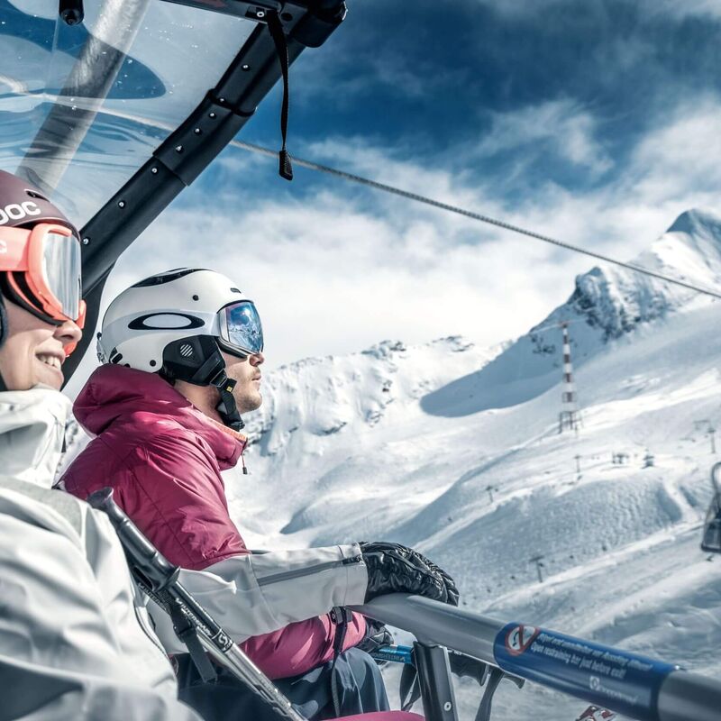 Skiers in the 8-seater chair of the GletscherJet 3 with a view of the summit of the Kitzsteinhorn