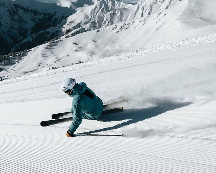 Skifahrer beim Carvingschwung auf der frischen Piste in Saalbach-Hinterglemm.