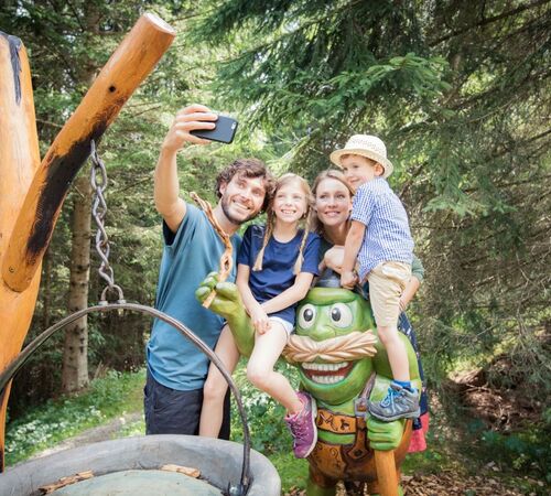 Familie hält Urlaubsmoment auf einem Erlebnis Wanderweg in Tirol mit einem Selfie fest