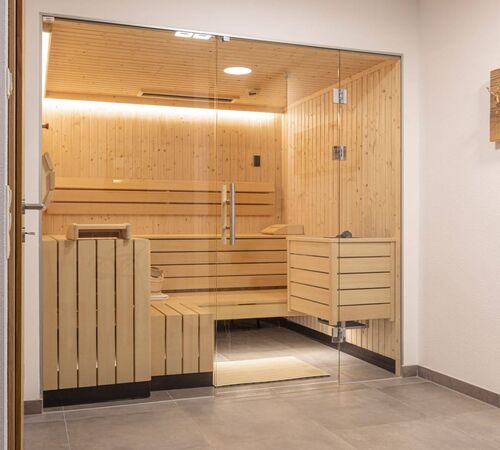 Moderne, private Sauna mit Holzausstattung und Glasfront im Ferienhaus