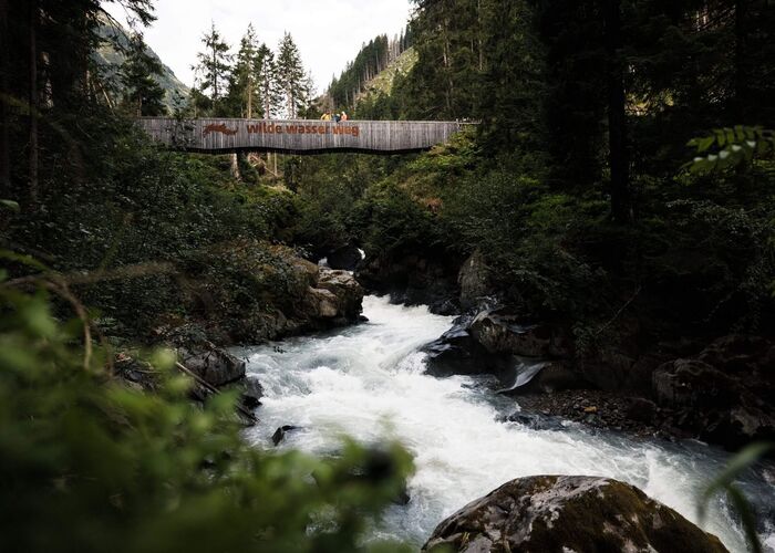 Wasser mit einer Brücke wo sich Leute darauf befinden
