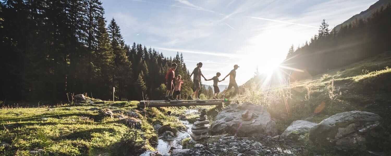 Familie wandern Hand in Hand über eine Brücke