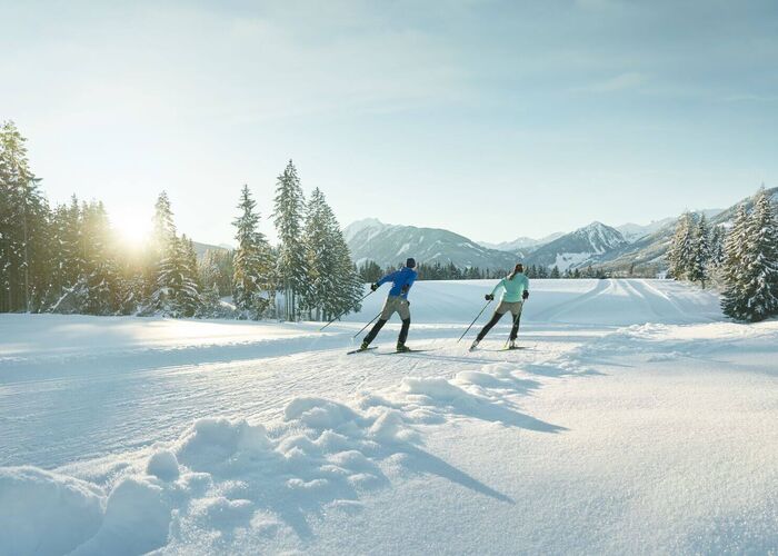 Zwei Langläufer auf perfekt präparierter Loipe in märchenhafter Winterlandschaft