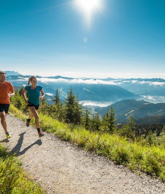 A couple running on a flat high altitude trail in the mountains in Zell am See.