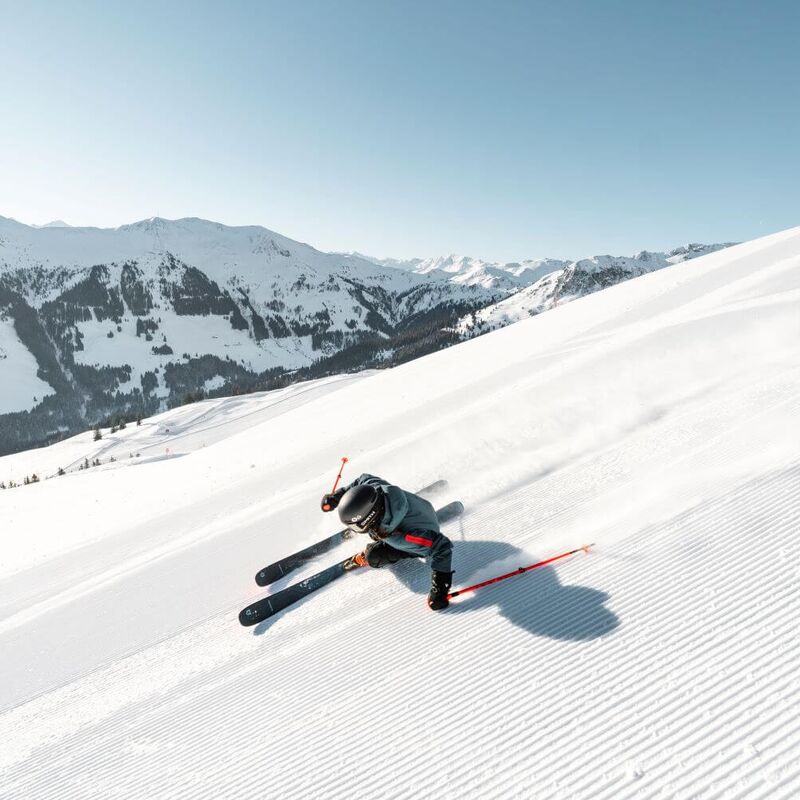 Skiers carving on a lonely, freshly groomed slope