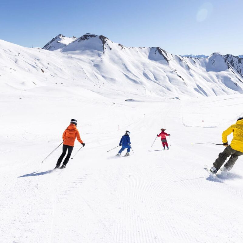 Parents with children skiing on a wide slope
