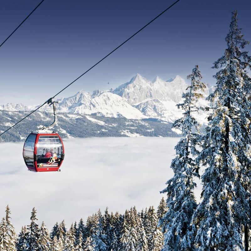 Red cable car over the sea of fog with mountain panorama