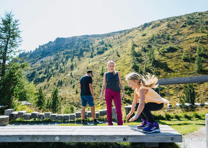 Familie spielt an einem Sommertag in Nocky’s Almzeit auf der Turracher Höhe in Kärnten