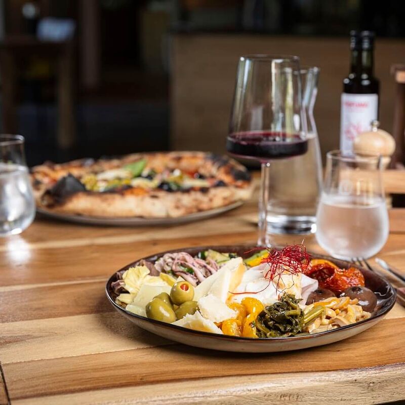 Tisch mit Antipasti und Pizza mangia! Saalbach