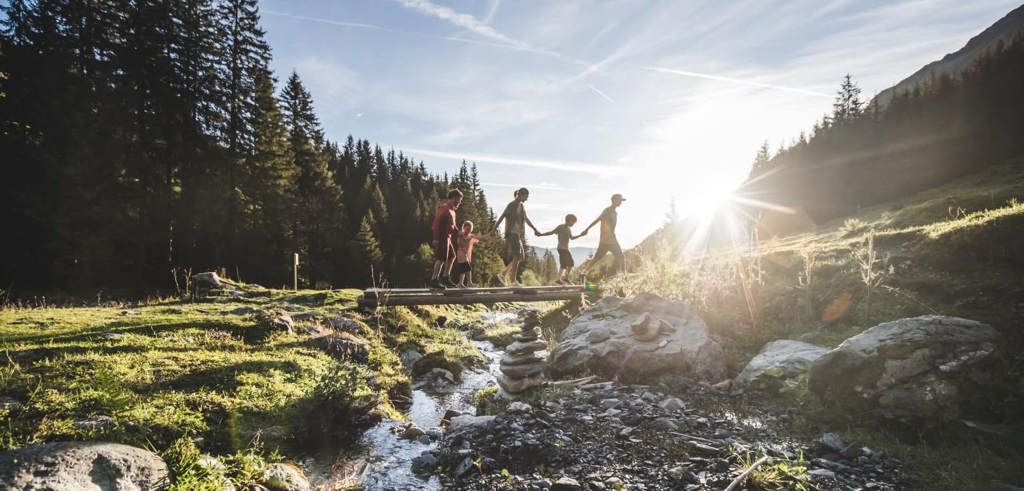 Familie wandern Hand in Hand über eine Brücke