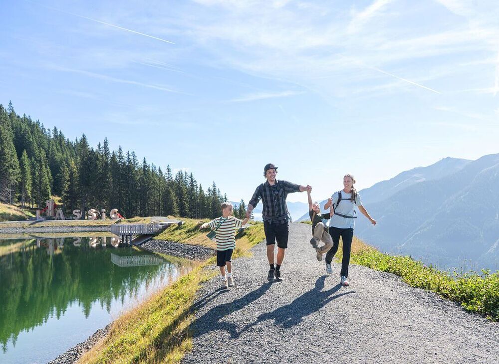 Family hiking carefree at the reservoir in Saalbach Hinterglemm