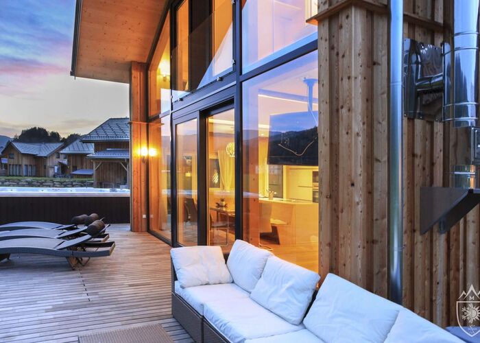Feriendorf Murau Chalet am Abend mit Swim Spa im Hintergrund