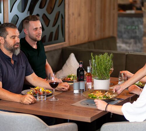 Kellnerin serviert köstliche regionale und internationale Gerichte im Restaurant