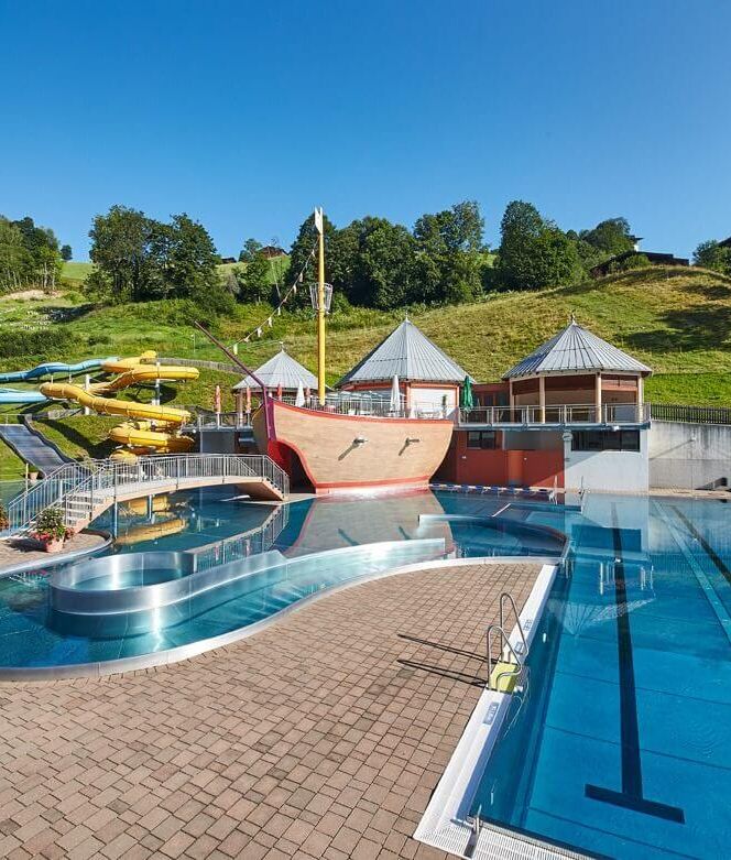 Outdoor pool with three water slides, pirate ship and sunbathing lawns.