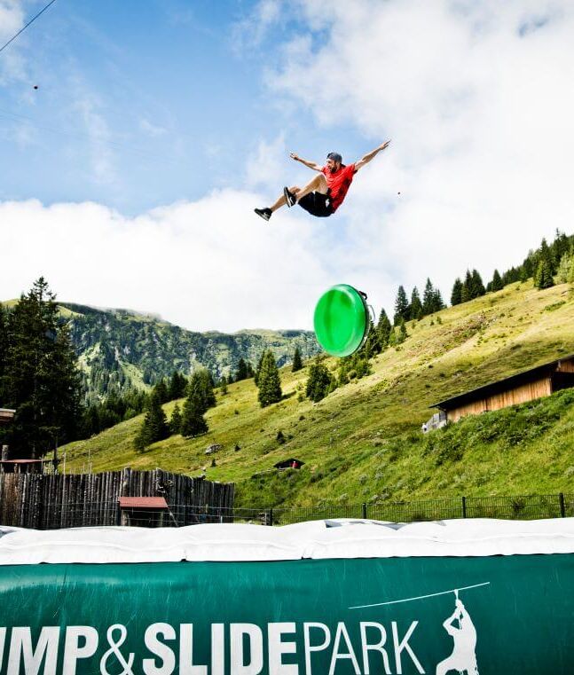 A young man soars several metres through the air before landing on a thick airbag.