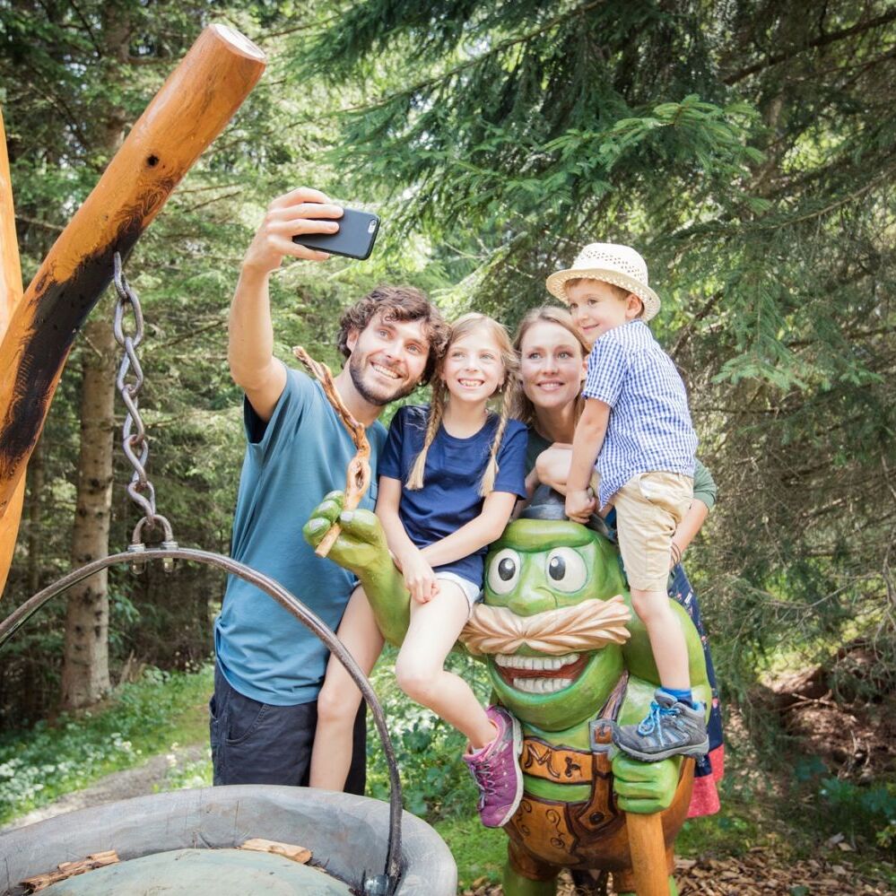 Familie hält Urlaubsmoment auf einem Erlebnis-Wanderweg in Tirol mit einem Selfie fest