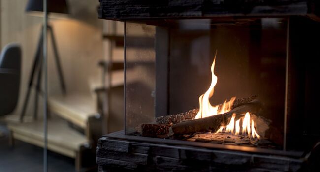 In einem Kamin mit Glasfenster brennt ein Feuer