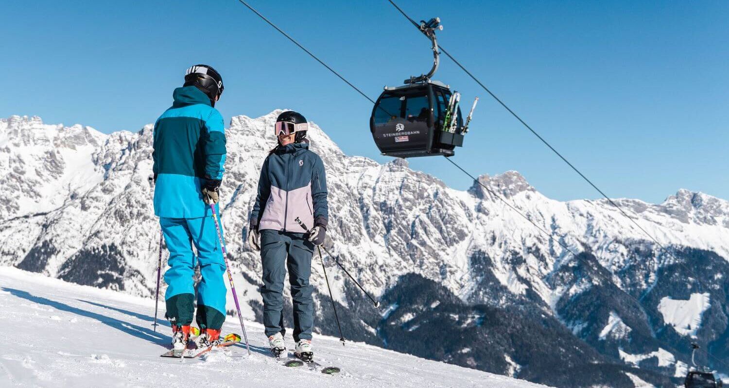 2 Skifahrer stehen unterhalb der Leoganger Steinbergbahn.