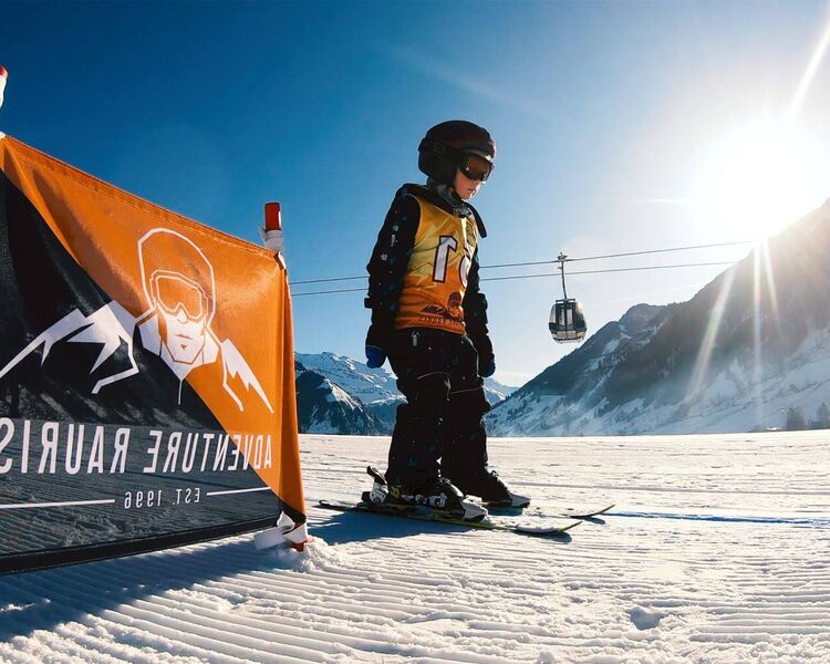 Kind bei seinen ersten Versuchen auf Skiern im flachen Kinderübungsgelände