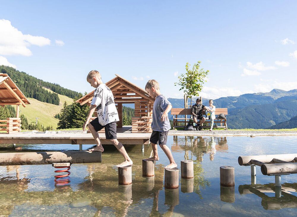 Children play in the water playground in the mountains