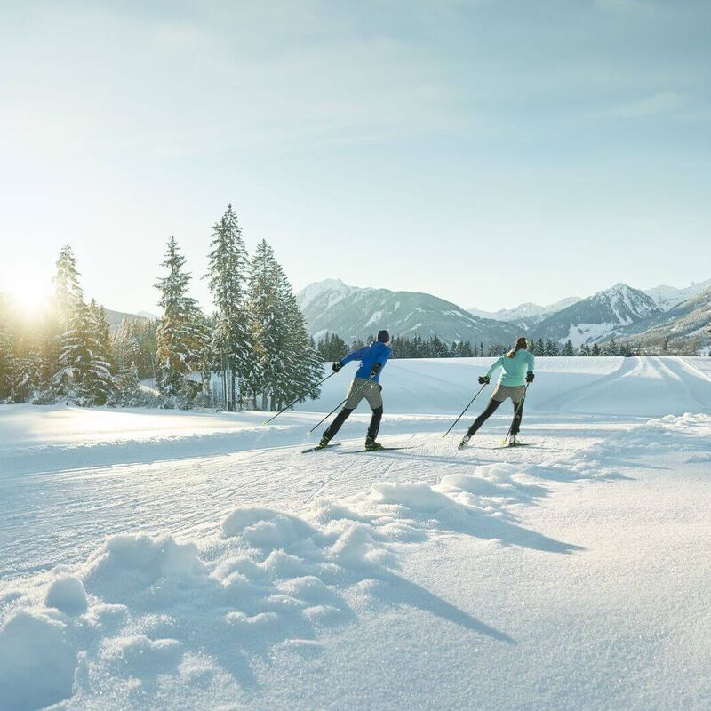 Zwei Langläufer auf perfekt präparierter Loipe in märchenhafter Winterlandschaft