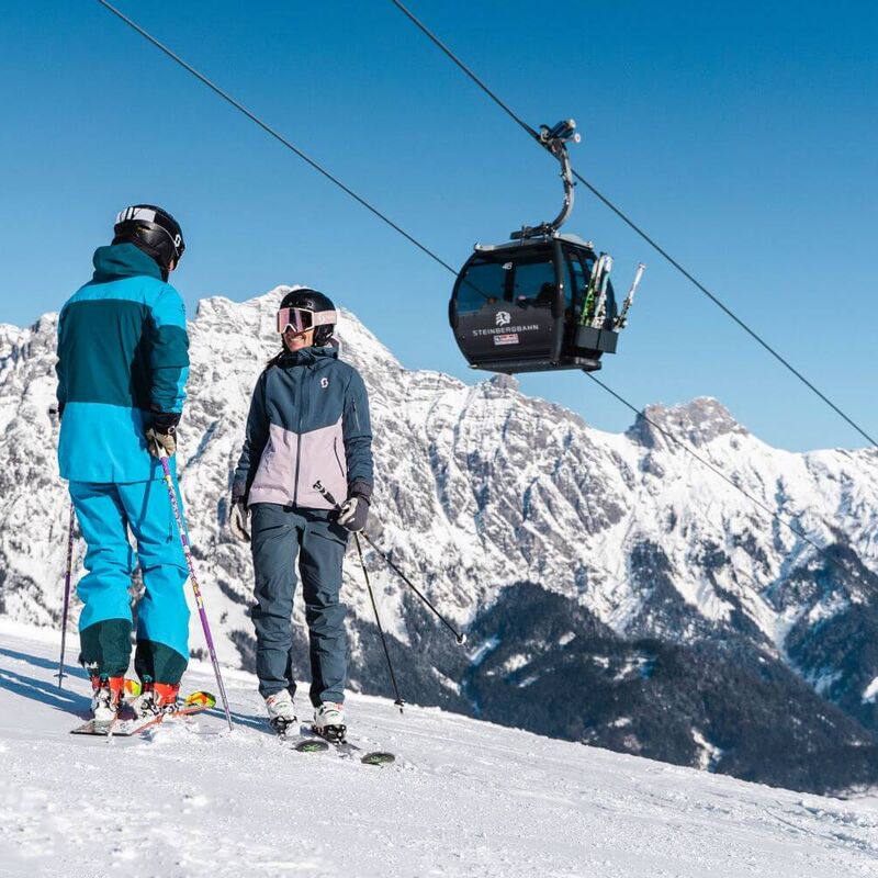 2 Skifahrer stehen unterhalb der Leoganger Steinbergbahn.
