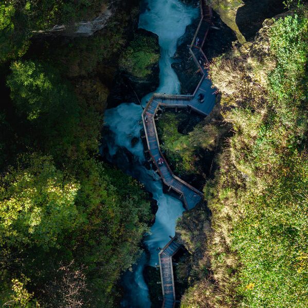 Blick von oben auf die Sigmund Thun Klamm mit tosendem Wasser und Holzsteigen.