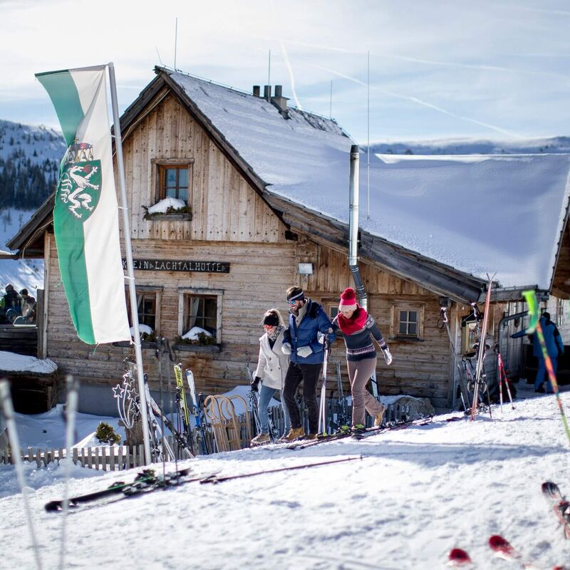 Alpine-style mountain hut, surrounded by snow and sunshine