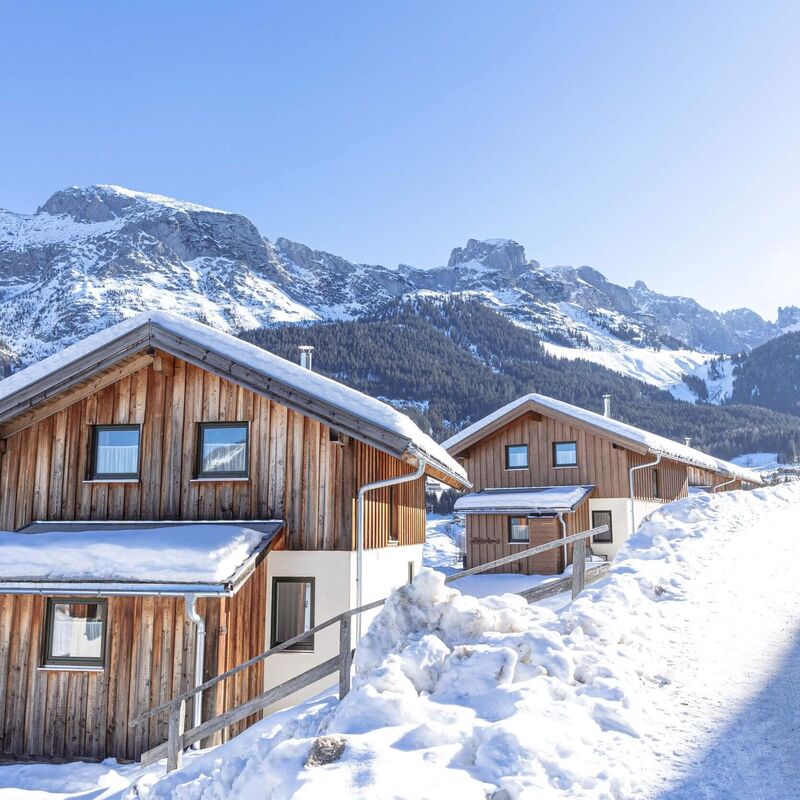 Gemütliche Ferienhäuser im Schnee mit Blick auf die Bischofsmütze