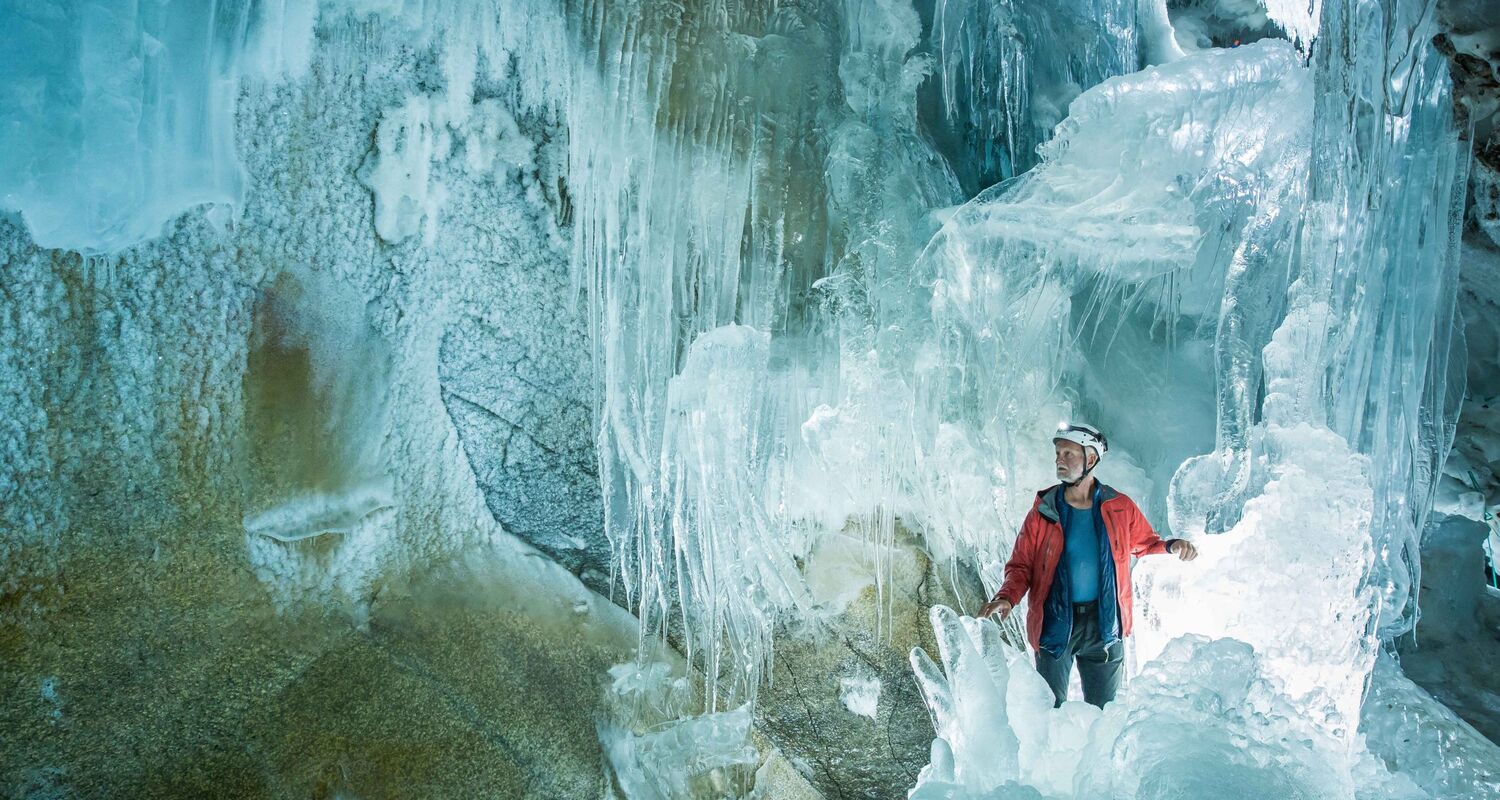 Blick in die Gletscherhöhle am Hintertuxer Gletscher im Zillertal, mit glitzernden Eisstalaktiten und gefrorenem Wasserfall. © Zillertal Tourismus / Bernhard Huber
