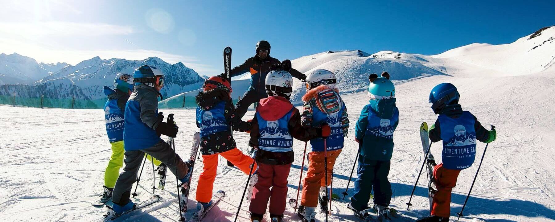 Skilehrer mit einer Kinderskigruppe auf der Piste