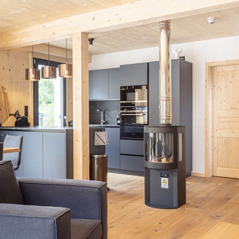 Offener Küchenblock mit moderner Ausstattung und Kamin mit Sichtfenster