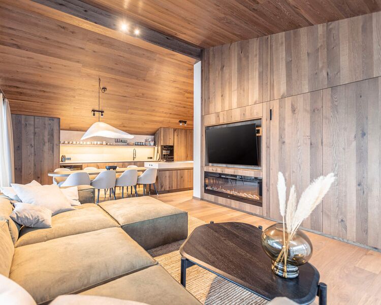 Wohnraum mit bequemer, stilvoller Couch und moderne Küche im Hintergrund