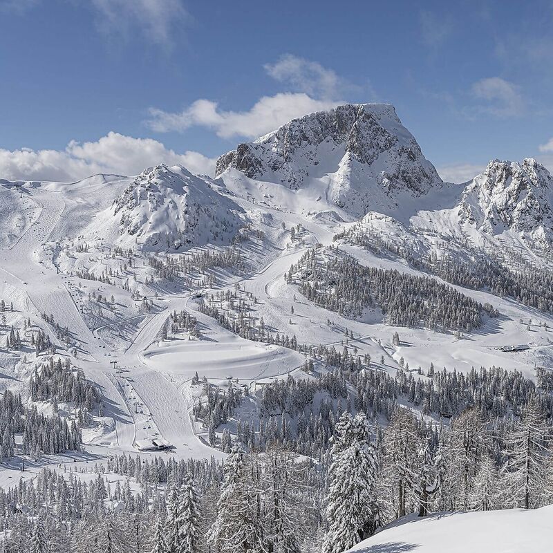 Schneebedeckte Berglandschaft mit Skipisten und Skiliften am Nassfeld in Kärnten
