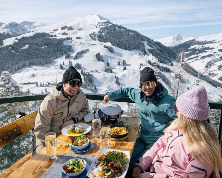 Freunde essen typisch regionale Speisen auf der Skihütte