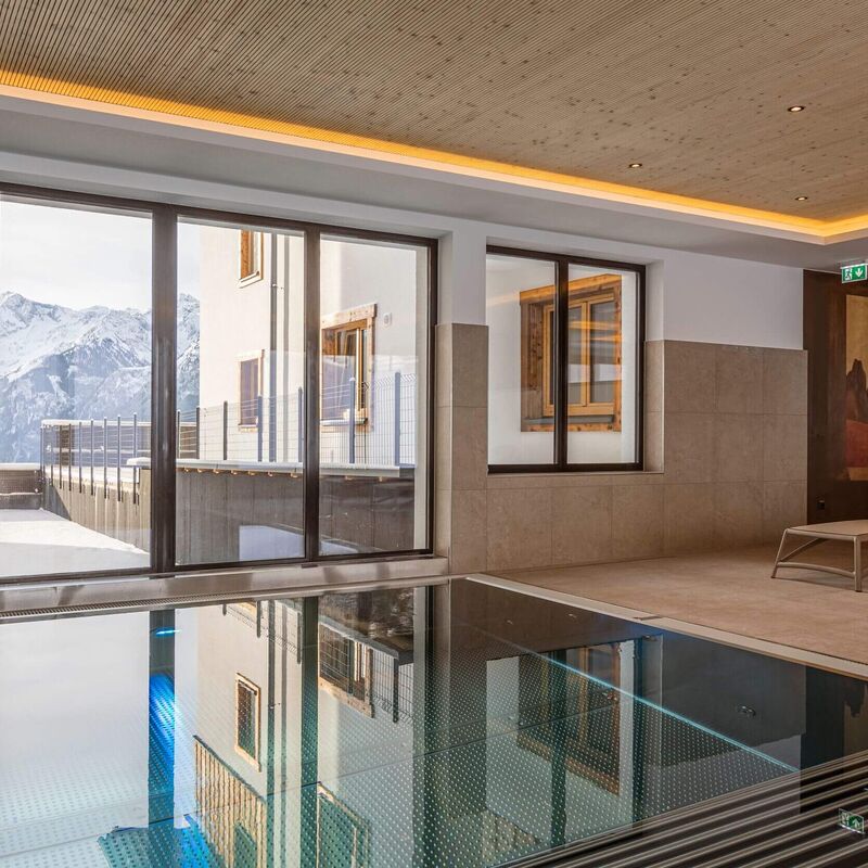 Hallenbad mit Liegegelegenheiten und einzigartigen Ausblick auf die Tauern