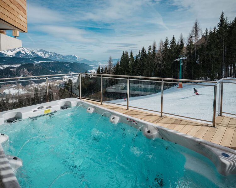 Gemütlicher Whirlpool auf der Terrasse eines Ferienhauses direkt an der Skipiste